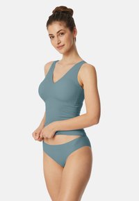 Light blue two-piece swimsuit featuring a v-neck top with wide straps and matching bikini bottom with a smooth texture and minimal design.