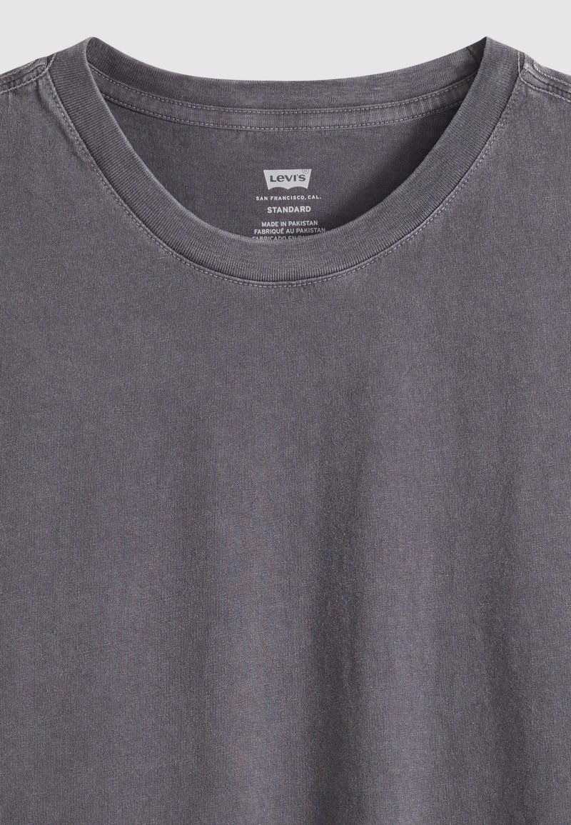 T-shirt Levi's gris foncé à col rond avec étiquette intérieure visible affichant la marque et les détails de fabrication.