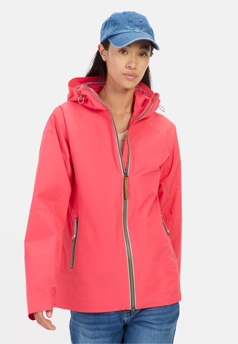 Pink waterproof jacket with a zip front, adjustable hood, and two side pockets. Worn with denim. Minimalistic design and smooth texture.