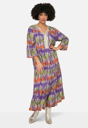Maxi jurk in paars, oranje en groene tie-dyeprint met V-hals en 3/4 mouwen. Beschikt over decoratieve details langs de halslijn.
