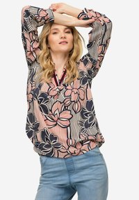 Langärmlige Bluse mit Blumenmuster in Rosa, Marineblau und Cremefarben; verfügt über einen V-Ausschnitt mit roten und marineblauen Akzenten; lockere Passform.
