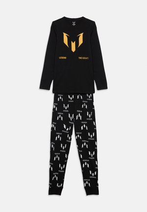 Haut noir à manches longues avec l'inscription dorée "Legend The G.O.A.T." et un logo, associé à un pantalon noir arborant des logos Messi blancs répétitifs et du texte.