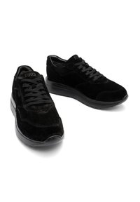 Czarne zamszowe trampki z czarną gumową podeszwą, z okrągłymi sznurówkami, wyściełanym kołnierzem i subtelnymi akcentami w postaci przeszyć.