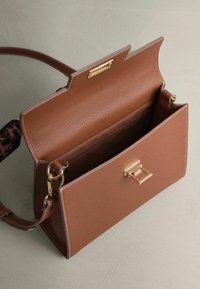 Brązowa skórzana torebka o fakturze, ze złotymi akcentami, zapięciem na klamrę i wewnętrzną kieszenią, z odpinanym paskiem w wzór lamparta.