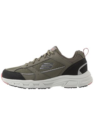 Olivengrøn sneaker med mesh-paneler, gråt logo, sorte og grå accenter, hvid sål og pink trækflap på hælen.