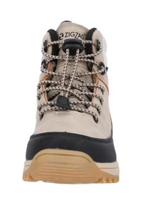 Scarpa da trekking beige con accenti neri e arancioni, caratterizzata da materiali testurizzati, un sistema di allacciatura pronunciato e una suola robusta e flessibile.