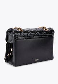 Torebka z pikowanej czarnej skóry z złotym łańcuchem, gładka konstrukcja i dekoracyjne chwosty. Na przedniej stronie znajduje się logo w kolorze złotym.