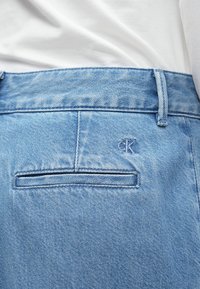 Απαλές γαλάζιες τζιν παντελόνες με λεπτομέρεια από τσέπη στο πίσω μέρος, που διαθέτουν ένα μικρό κεντημένο λογότυπο και ζώνη με θηλιές.