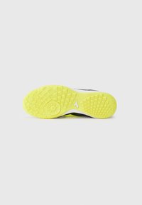 Sole of black and neon yellow sports shoe with textured grip patterns and brand logo centered on white background.