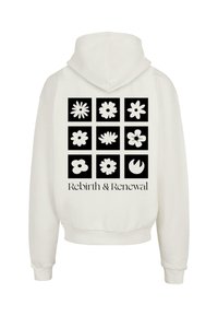 Sudadera blanca con un gráfico de nueve iconos de flores en cuadrados negros. El texto dice "Renacimiento y Renovación" debajo del diseño.