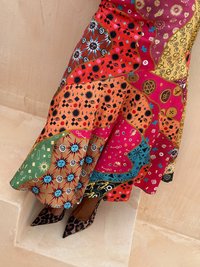 Kleurrijke patchwork rok met verschillende patronen in rood, oranje, groen, blauw en bruin. Gecombineerd met zwart en bruin luipaardprint hakken.