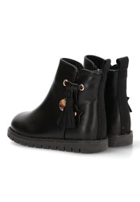 Botas negras hasta el tobillo hechas de cuero suave con un acento de tela texturizada. Cuenta con un borlas, herrajes en tono dorado y una suela de goma resistente.