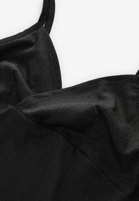 Zwarte top met dunne bandjes, een gestructureerd oppervlak en een subtiele glans, met een gladde stofafwerking en een getailleerd ontwerp.