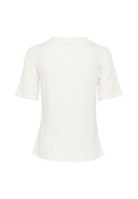 T-shirt blanc avec des manches en dentelle texturée et un col rond. Le corps est lisse avec des manches courtes légèrement évasées.