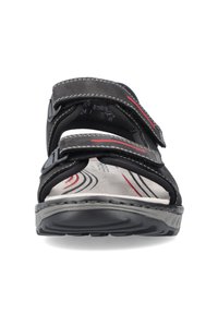 Sandale noire avec deux sangles Velcro ajustables, semelle rembourrée et semelle en caoutchouc. La doublure intérieure présente une texture douce avec des accents rouges.