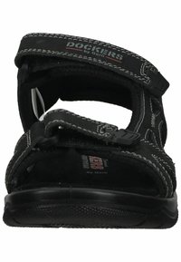 Schwarze Sandalen mit verstellbaren Riemen, aus weichem Stoff und Gummi. Mit weißen Nähten und einer strukturierten Sohle für besseren Halt.