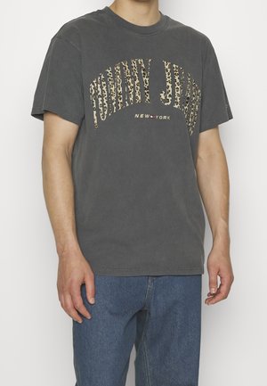 Grijze katoenen t-shirt met korte mouwen, met een luipaardprint tekstontwerp "TOMMY JEANS" en "NEW YORK" in contrasterende kleuren.