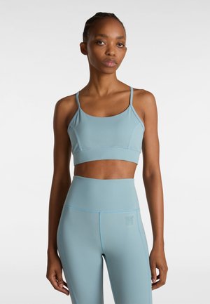 Light blue sports bra and high-waisted leggings made from stretchy material; features thin straps and subtle stitching details.