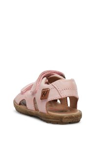 Růžová kožená sandál s otevřeným designem, suchými zipy a hnědou gumovou podrážkou. Obsahuje propracované výřezy a malou nášivku s logem.