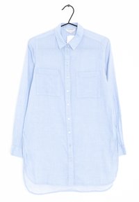Jasnoniebieska koszula z długim rękawem, zapinana na guziki, z dwiema kieszeniami na piersi, zakrzywionym dołem i gładką teksturą materiału.