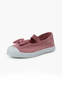 Růžová plátěná bota s bílou gumovou podrážkou, s mašlí na svrchním popruhu a zaobleným designem špičky.