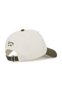 Gorra blanca de béisbol con visera verde, con el texto escrito "Vacancy du Tal" y una correa ajustable con herrajes metálicos en la parte trasera.