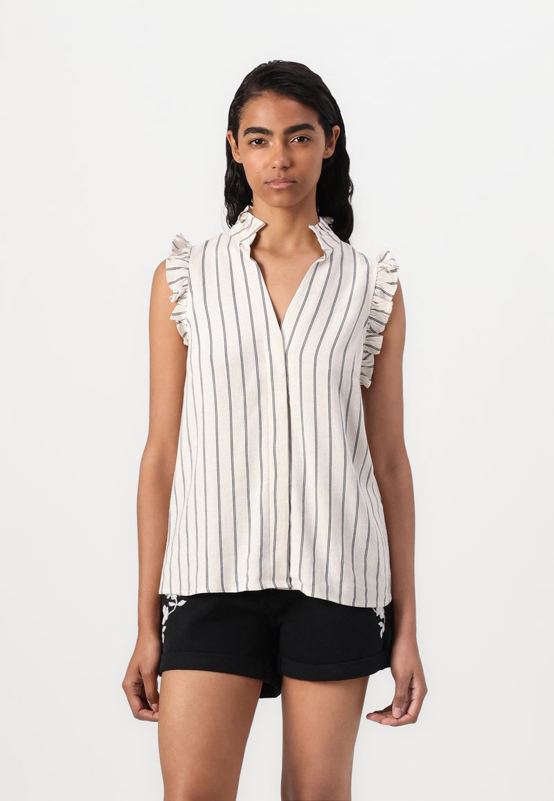 Blouse sans manches rayée en tissu léger, avec un col aux bords volantés. Les rayures sont marines sur un fond crème.