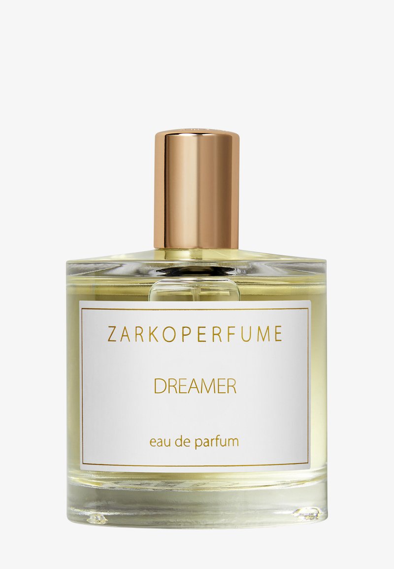 Eau de parfum-flaske med klar glasskropp, gullhette og en hvit etikett med teksten "ZARKOPERFUME DREAMER" i gullbokstaver.