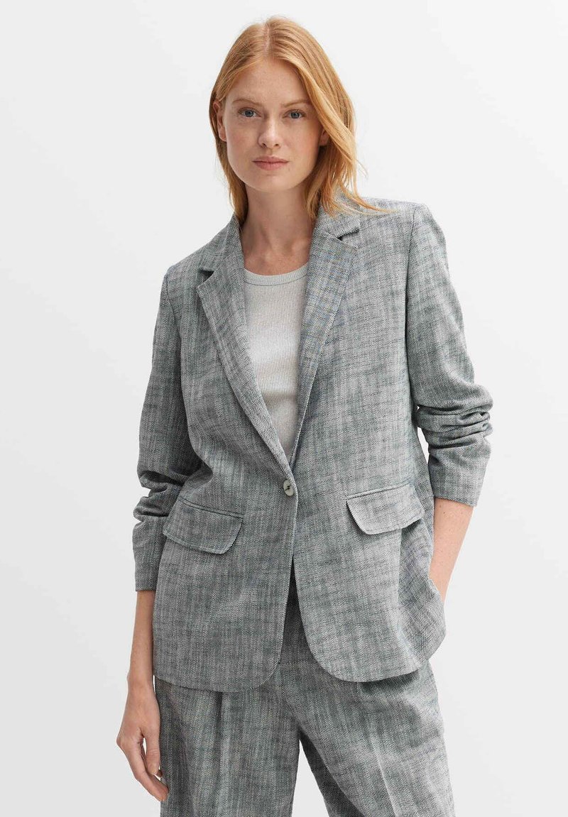 Grijze geruite blazer met een geknipt revers, twee voorzakken, een enkele knoopsluiting en een relaxte pasvorm. Gelaagd stof met gevarieerde patronen.