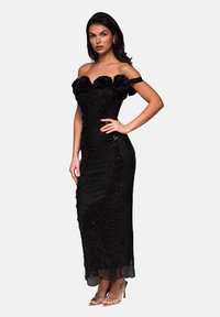 Černé večerní šaty s designem bez ramínek, texturovaná tkanina, květinové detaily na výstřihu a korálková výzdoba; přiléhavý silueta.