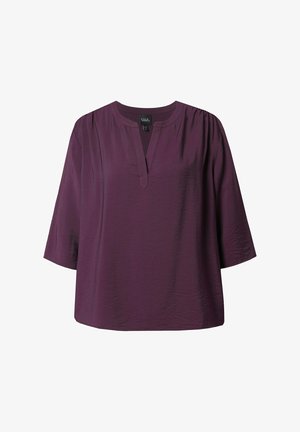 Blusa viola a maniche corte con scollatura a V, caratterizzata da leggeri arricciamenti alle cuciture delle spalle e una vestibilità rilassata. Realizzata in tessuto leggero.