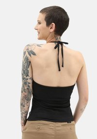 Top nero a collare realizzato in tessuto elasticizzato, con un design aderente e spalline legate al collo, esposto su uno sfondo neutro.