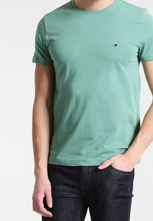 Grünes Kurzarm-T-Shirt aus Baumwolle mit rundem Halsausschnitt und kleinem Logoakzent auf der Brust. Schlichtes, einfarbiges Design.