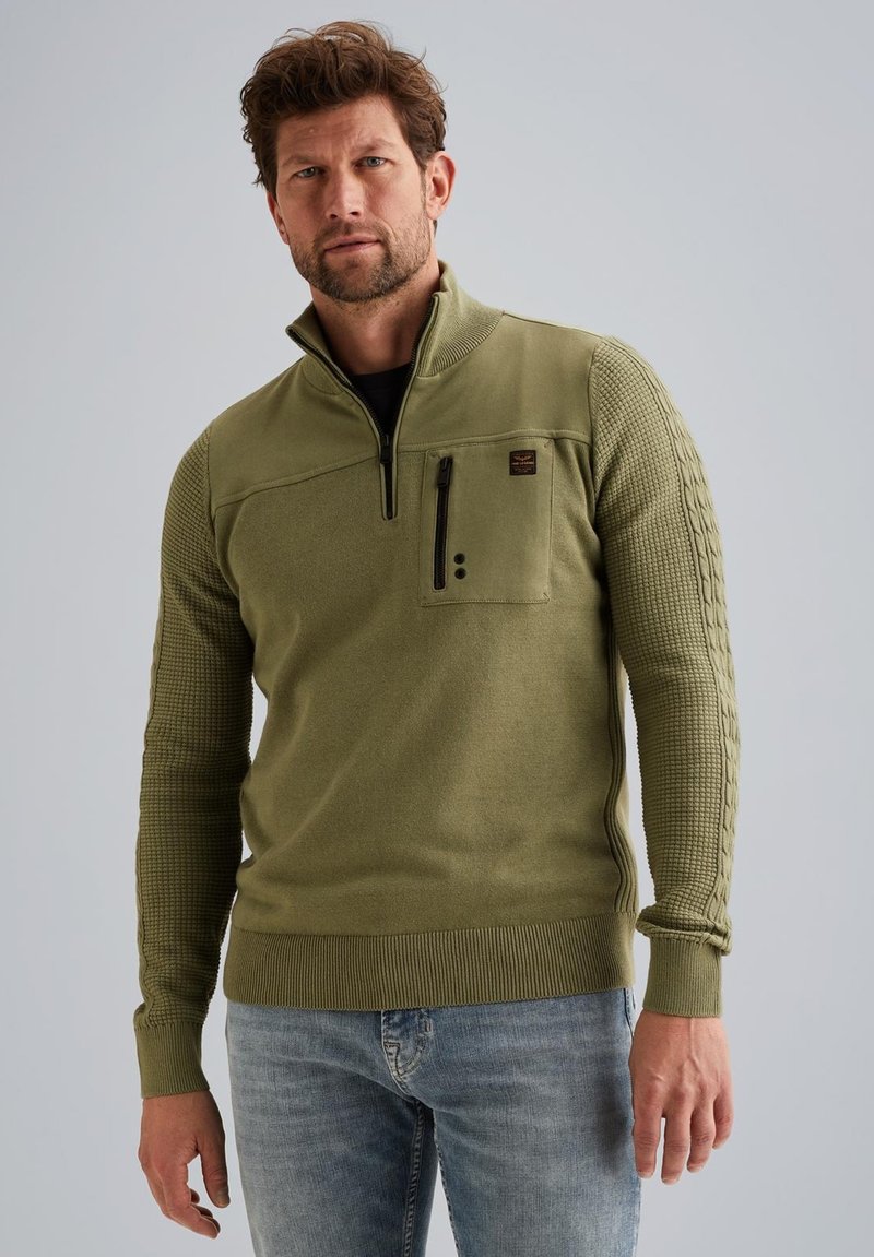 Olivengroen pullover met een kwartrits, gestructureerde mouwen en een borstzak. Heeft ribgebreide manchetten en zoom, gemaakt van een zachte stof.