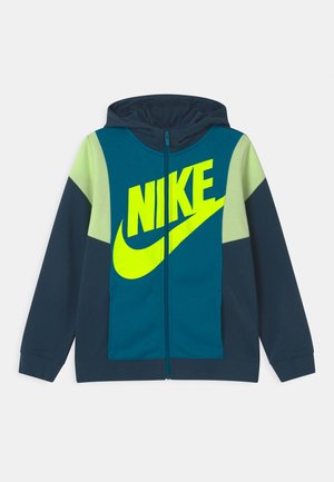 Nike Kapuzenjacke mit durchgehendem Reißverschluss, gestaltet mit einem geteilten Design in Marineblau und Türkis, verziert mit einem neongrünen Logo und Akzenten auf den Schultern. Weiche Stoffstruktur.