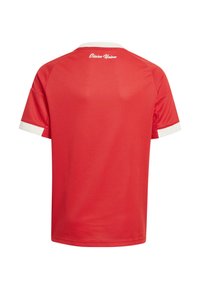 Maillot de sport rouge avec col et bordures de manches blanches, texte "Eisern Union" imprimé en blanc sur le haut du dos.