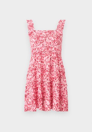 Ροζ και κόκκινο floral αμάνικο φόρεμα με βολάν στα τιράντες και φούστα με στιβάδες, εμφανίζεται πάνω σε απλό ανοιχτό φόντο.