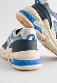 Sneakers w granatowo-błękitnym wzorze, gładką skórą i oddychającą siateczką, z masywną podeszwą i teksturowanymi akcentami.