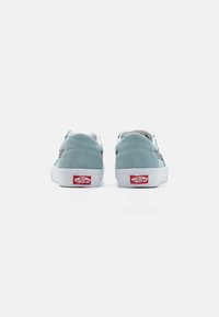 Himmelblaue Wildledersneaker mit weißen Gummisohlen, runder Spitze und einem roten Logoakzent an der Ferse. Verfügt über minimale Designelemente.