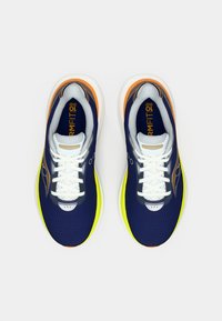 Pár bežeckých topánok v námorníckom modrom, oranžovom a žltom prevedení s bielymi šnúrkami zhora na bielom pozadí.