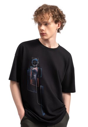 T-shirt in cotone nero con vestibilità morbida, caratterizzato da un design grafico astratto e colorato sul davanti. Maniche corte e scollatura a girocollo.