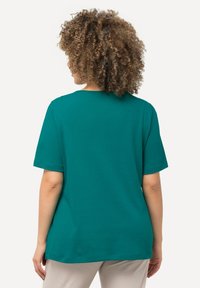 Teal korte mouwen t-shirt met een ontspannen pasvorm en ronde hals. Zachte katoenen stof, gladde textuur en geen zichtbare patronen of accenten.