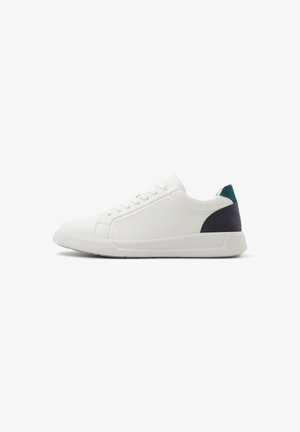 Hvide sneakers i canvasmateriale, rund form, teksturerede sider og en mørkegrøn og marineblå accent på hælen. Snørelukning.