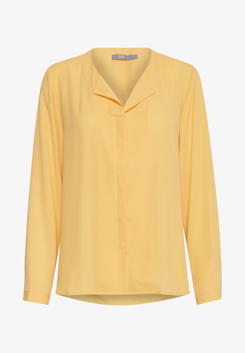 Długo rękawowa żółta bluzka z lekkiego materiału, z dekoltem bez kołnierzyka, plisą z przodu i lekko zaokrąglonym dołem.