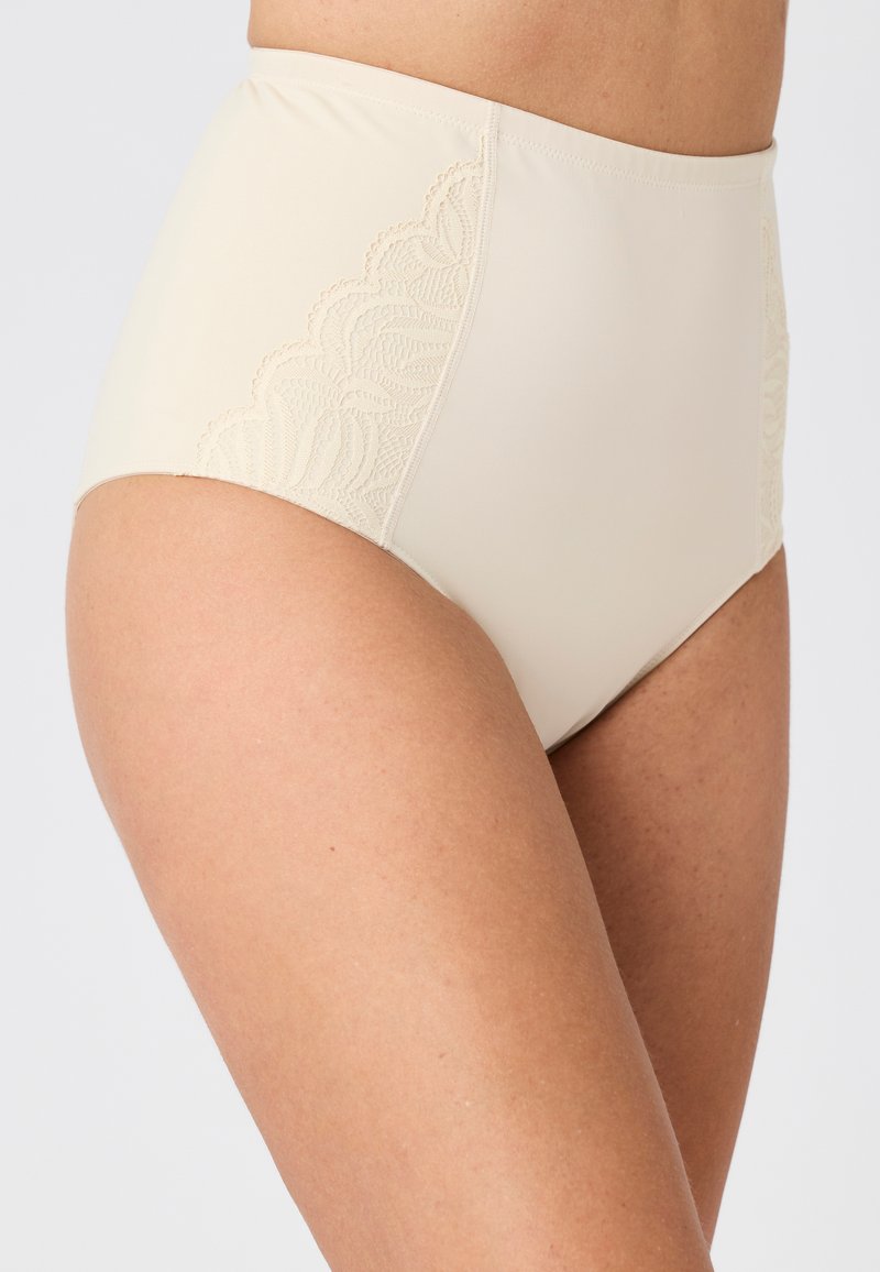 Slip beige a vita alta con un dettaglio in pizzo a trama sulla parte laterale. Tessuto liscio con un aspetto complessivamente morbido.