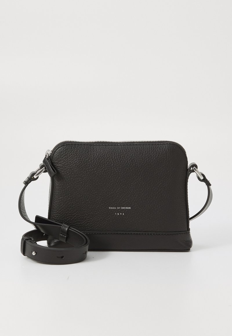 Borsa a tracolla in pelle nera texturizzata con manico regolabile e zip argentata, impreziosita dalla scritta "Tiger of Sweden 1903" sul davanti.