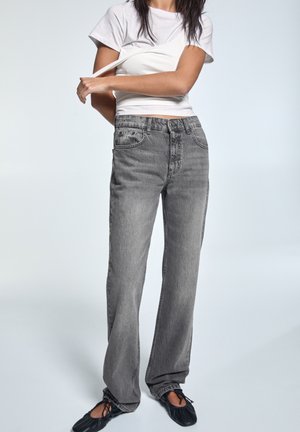 Harmaat korkeavyötäröiset farkut rentoa leikkausta, viidellä taskulla ja farkkukankaalla. Yhdistetty valkoiseen istuvaan t-paitaan ja mustiin ballerinoihin.