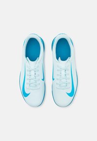 Heledad sinised spordijalatsid tekstuurse disainiga, millel on sinine swoosh-logo ja valged paelad, esitlevad siledat pealmist osa ja pehmet tallatäidet.