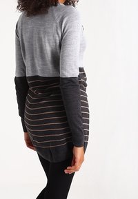 Sweter z długim rękawem w kolorze szarym i czarnym w poziome paski. Miękka dzianina, luźny krój, okrągły dekolt oraz ściągacze przy rękawach i u dołu.