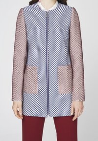Textured jacket with a geometric pattern in blue and white, featuring long sheer sleeves and two beige pockets. Zipper closure in front.